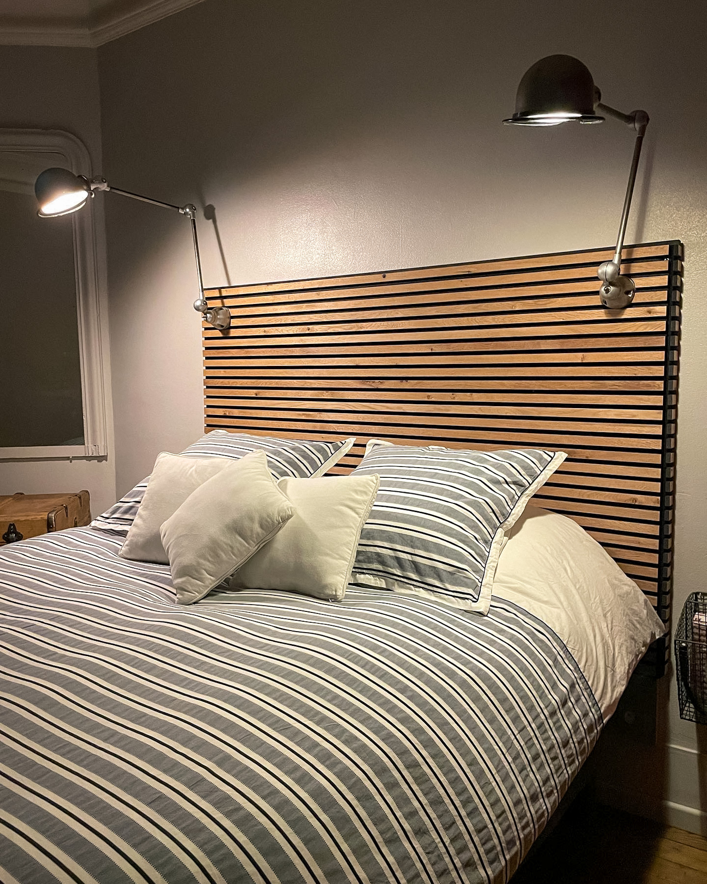 têt de lit en bois avec des lampes industrielles
